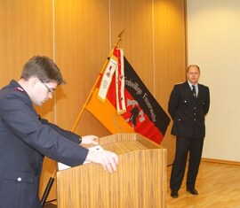 Vorsitzender des Kreis&shy;feuerwehr&shy;verbandes Spree-Neiße e.V. verliest die Urkunde zur Auszeichnung des Kam. Ronny Heppchen