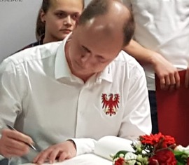 Physiotherapeut Ronny Heppchen trägt sich ins goldene Buch ein