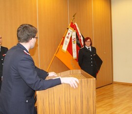 Vorsitzender des Kreis&shy;feuerwehr&shy;verbandes Spree-Neiße e.V. verliest die Urkunde zur Auszeichnung der Kamd. Katrin Kraljic