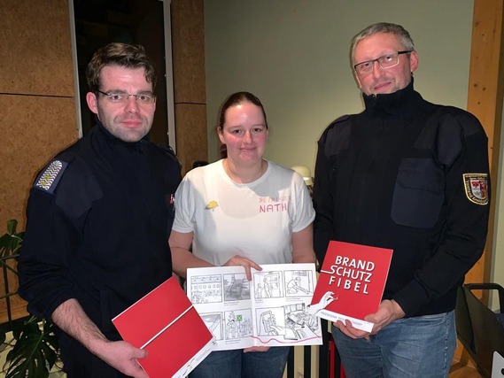 Robert Buder (Vorsitzender KFV), Nathalie Scherer (Brandenburgs beliebteste Brandschutzerzieherin) und Stefan Kothe (amt. Kreis&shy;jugend&shy;feuerwehrwart) präsentieren die dt-polnischen Brandschutzfibeln