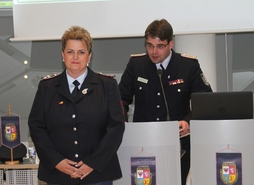 Robert Buder (Hintergrund) verliest die Urkunde zu Auszeichnung der ehemaligen Schatzmeisterin der Kreis&shy;jugend&shy;feuerwehr Spree-Neiße