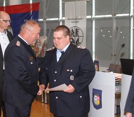 LFV Präsident Werner-Siegwart Schippel gratuliert Stephan Müller für seine Auszeichnung mit dem Ehrenzeichen des Kreis&shy;feuerwehr&shy;verbandes Spree-Neiße e.V.