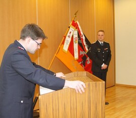 Vorsitzender des Kreis&shy;feuerwehr&shy;verbandes Spree-Neiße e.V. verliest die Urkunde zur Auszeichnung des Kam. Matthias Geigk